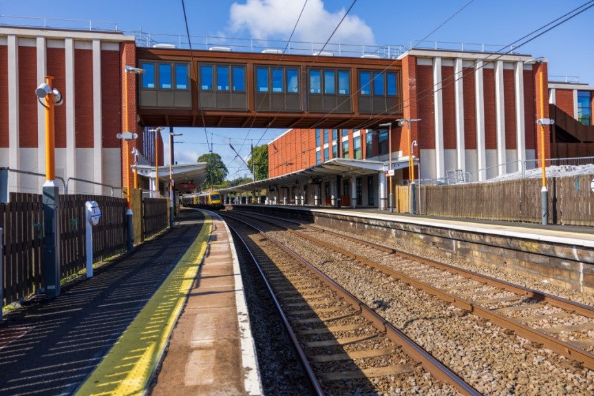 Photo of both new station buildings and the rail link bridge, with a view along the tracks.