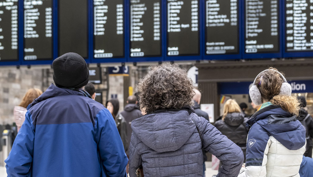 People looking at station departure board