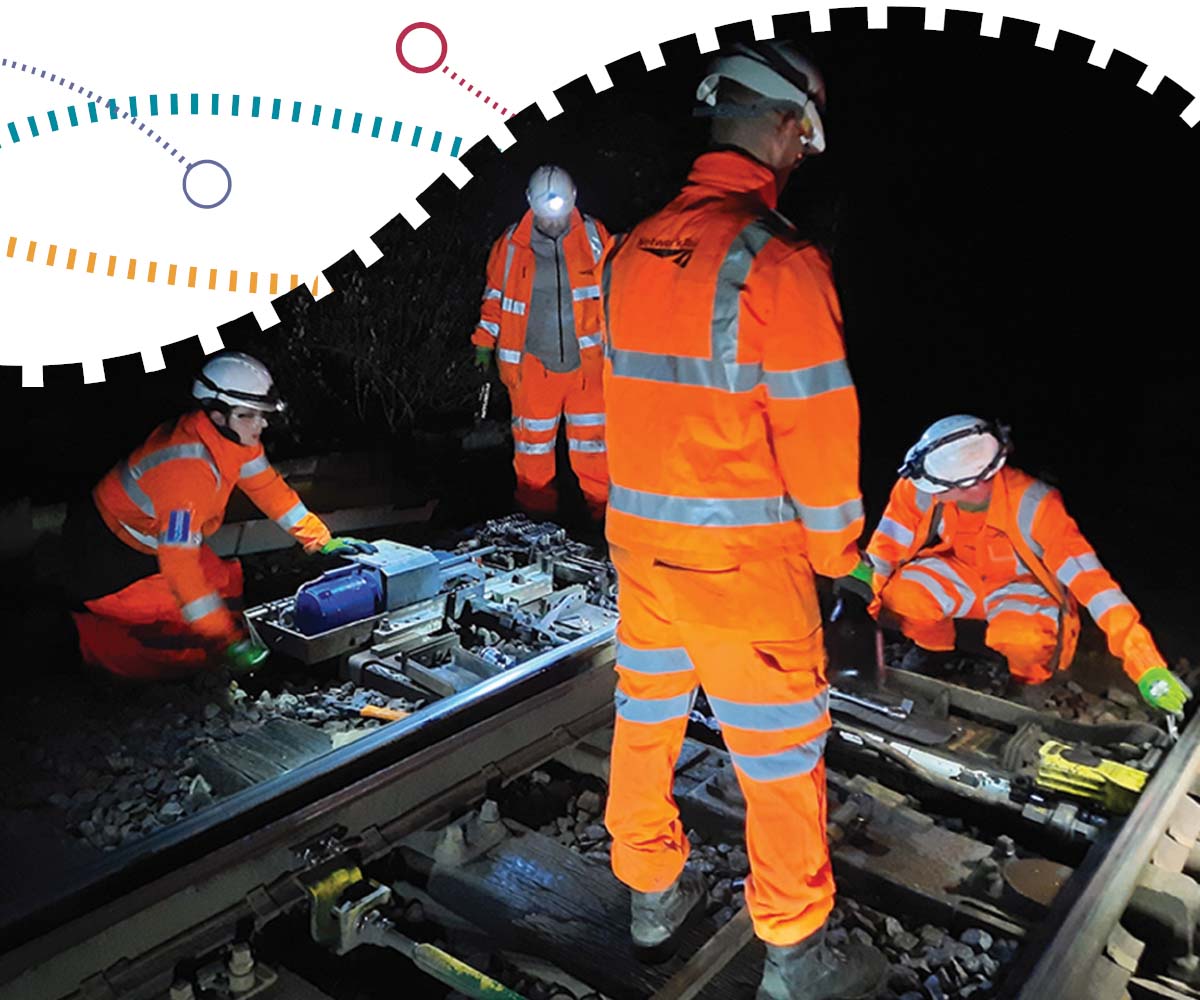 Rail maintenance workers in high-visibility clothing during a night shift. 