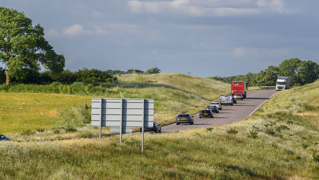 A view of the A45 with vehicles on the road and countryside surrounding it.