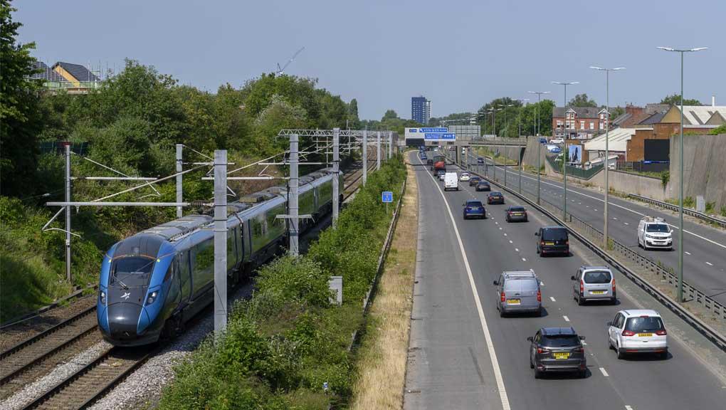 Railway track with train beside a road