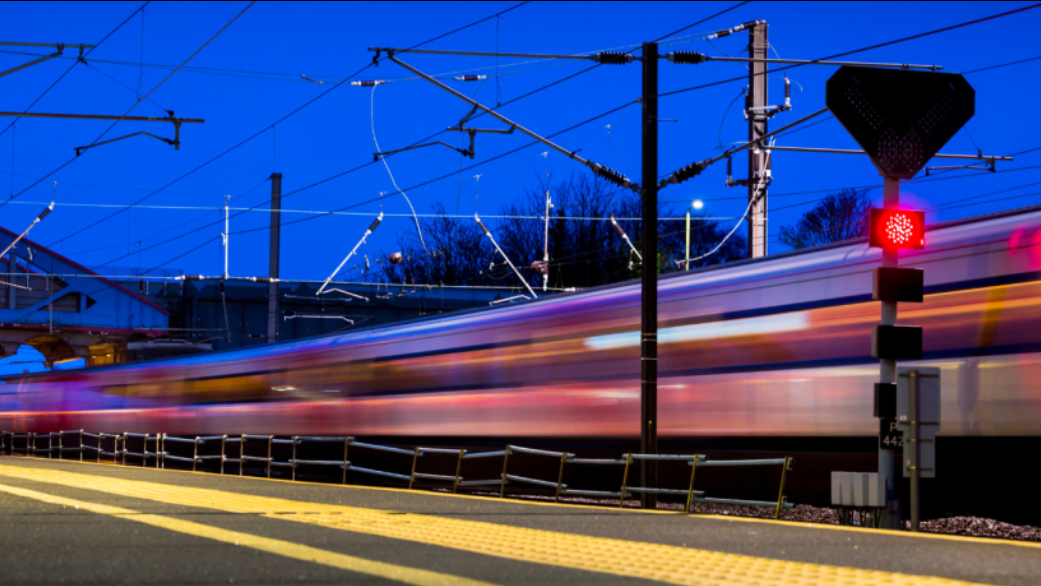 Train passing a station platform at night