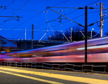 Train passing a station platform at night